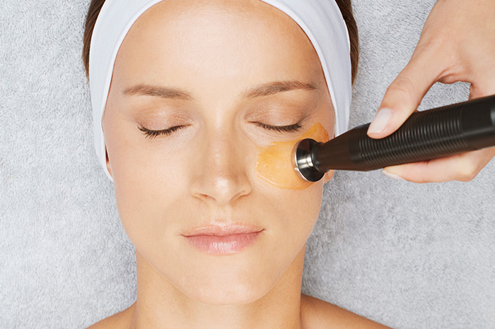Woman getting under eye treatment with a serum and the DF Mobile Machine